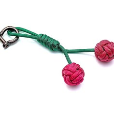 a green and pink rope with two balls attached to each other on a white background