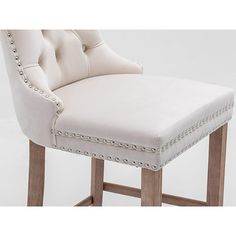 a white upholstered bar stool with studding