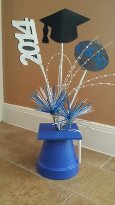 an image of graduation decorations on the floor with balloons and streamers in blue bucket