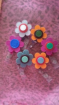 several plastic flowers are sitting on a pink table cloth, with one flower in the center