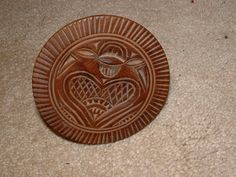 a wooden plaque with two hearts and a bird on it's side sitting on the floor