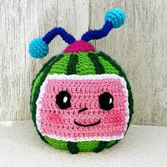 a crocheted watermelon purse with a smiling face