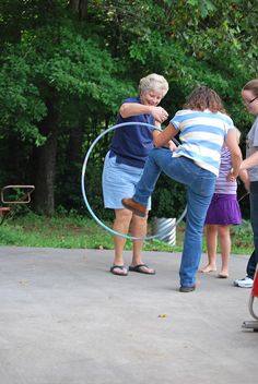 a group of people standing around each other with a hula hoop in front of them