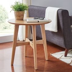 a living room with a couch, chair and table next to a potted plant