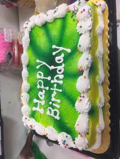 a green birthday cake with white frosting and sprinkles