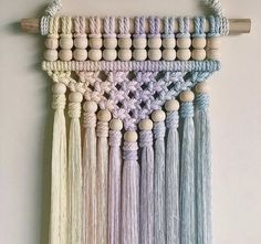 macrame wall hanging with wooden beads and tassels in pastel colors