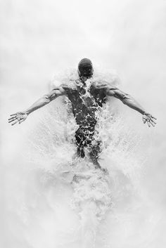 a man standing in the water with his arms outstretched