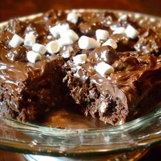 a chocolate dessert with marshmallows on top in a glass pie dish, ready to be eaten