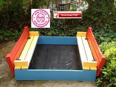 an outdoor play area made out of wood and painted blue, yellow and red with a sign above it that says down town pup