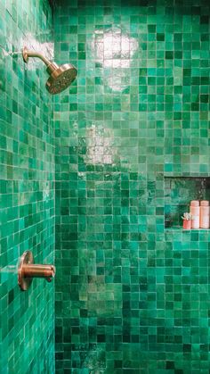 a green tiled bathroom with copper faucet and soap dispenser on the wall