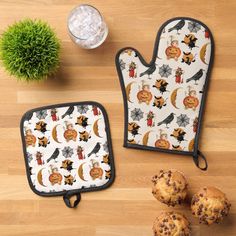 two oven mitts and some muffins on a table