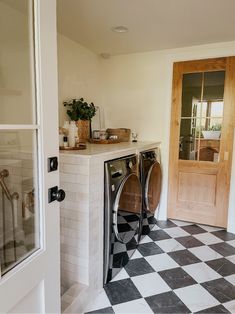 a washer and dryer in a room with black and white checkered floor