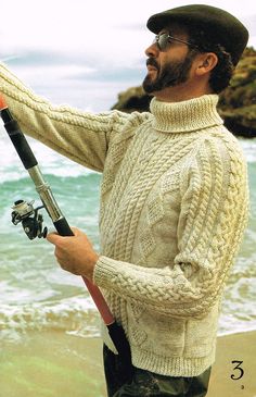 a man holding a fishing rod on the beach