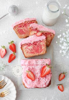 strawberry shortcakes with powdered sugar and fresh strawberries on the side next to a glass of milk