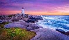 a lighthouse on top of a rocky cliff next to the ocean at sunset or dawn