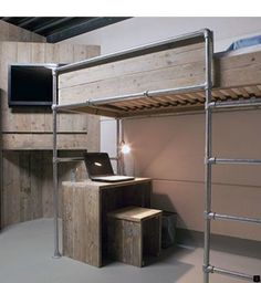 there is a bunk bed with a desk and laptop on the bottom shelf next to it