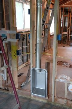 the inside of a house being built with wood framing and electrical equipment on the floor