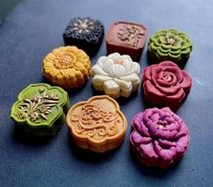 there are many different types of soaps on the table together and one is decorated with flowers