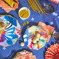 colorful plates and napkins on a blue table cloth