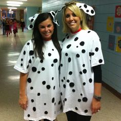 two women dressed in dalmatian costumes standing next to each other on the hallway