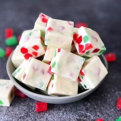 a bowl full of white chocolate with red, green and pink hearts on it's side