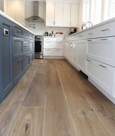 a kitchen with wood floors and white cabinets