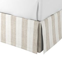 the bed is made up with white and beige striped sheets