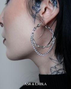 a close up of a person with tattoos on their face and behind them is an ear chain