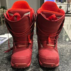 a pair of red snow boots sitting on top of a counter