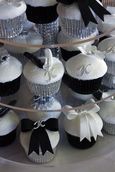 several cupcakes with black and white bows on them