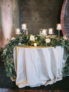 a table with candles and greenery on it