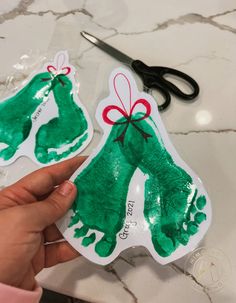 someone is holding out their handprinted christmas stocking ornament for the kids to make