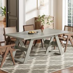 a dining room table with chairs and a bowl of fruit on the table next to it