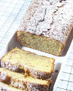 a loaf of cake sitting on top of a white tray next to slices of bread