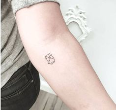 a small elephant tattoo on the left inner forearm and arm, with an outline in the middle