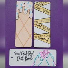 two bookmarks with handwritten words on them, one is holding a doughnut and the other has don't cross do not cross