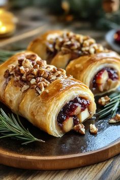 two cranberry and walnut pastries on a wooden platter with pine needles