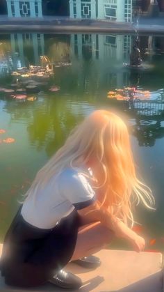 a woman sitting on the edge of a body of water