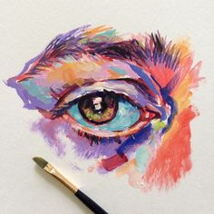 an eye painted with colored pencils and watercolor on white paper next to a brush