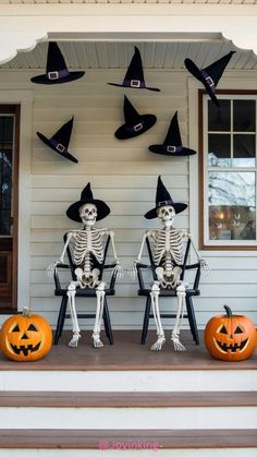 three skeletons sitting on the front porch decorated for halloween