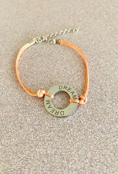 Wear your dreams on your wrist, be inspired and live your mantra. Silver stainless steel circle DREAM stamped bracelet with peach silk cording & silver adjustable clasp. Lead & nickel compliant Adjustable Nickel-free Orange Bracelets, Adjustable Nickel-free Orange Bracelet, Dream Bracelet, Stamped Bracelet, Silk Cord, Be Inspired, Alex And Ani Charm Bracelet, Mantra, Charm Bracelet