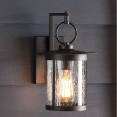 an outdoor wall light with a clear glass shade