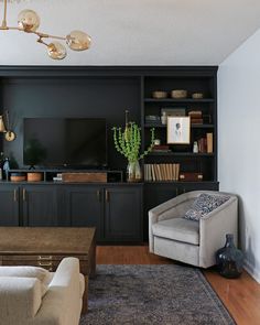 a living room filled with furniture and a flat screen tv on top of a wooden entertainment center