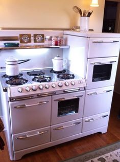 a white stove top oven sitting inside of a kitchen