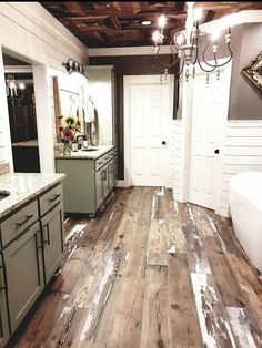 a bathroom with wood flooring and white walls in the background, including a chandelier