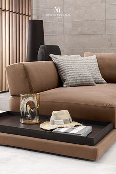 a living room with a brown couch and pillows on the floor next to a coffee table