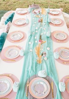 a table set up with plates and place settings for an ocean themed party or bridal