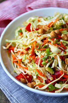 a white bowl filled with coleslaw and peanuts