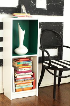 a book shelf with books and a chair next to it