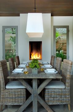 a dining table with chairs around it and a fire place in the middle between them